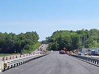 View of the length of Pleasant Cove detour road with vehicles at the end.